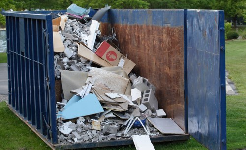 Company vehicle and crew preparing a skip at a residential site